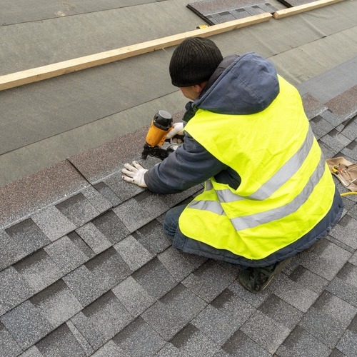 a worker installing a shingle roof