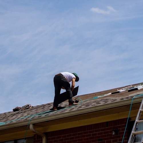 worker installing an asphalt shingle roof