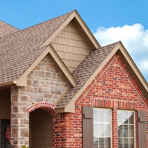 a brick home with asphalt shingle roofing