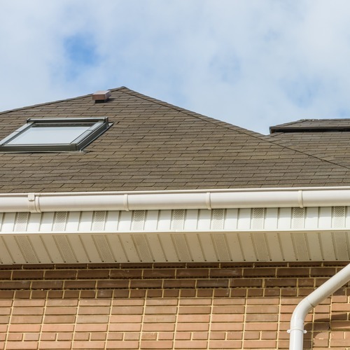 view from below of a shingle roof and gutters