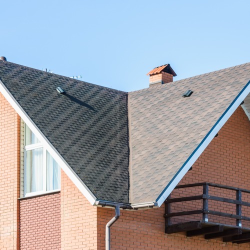 a brick home with a shingle roofing system