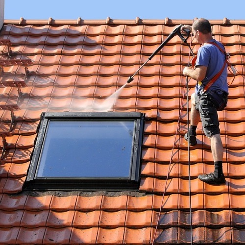 A Roofer Washing a Roof
