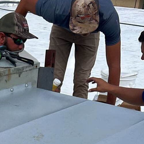 Roofers Check for Leaks on a Flat Roof.