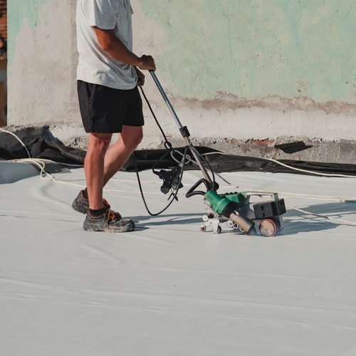 A Roofer Installs Flat Roofing